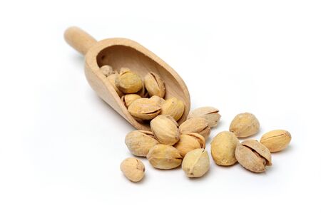 Pistachio on wooden scoop on white backgroundの写真素材
