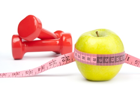 Apple with measuring tape on the background of a dumbbellの写真素材