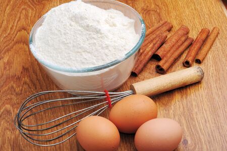 An image of three eggs with flour and cinnamon on a wooden tableの写真素材