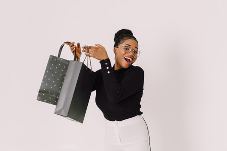 Portrait of young beautiful attractive African woman smiling and joyful with shopping bags.