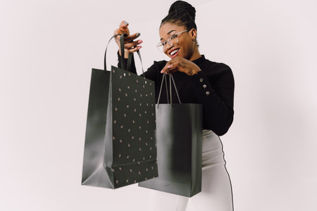 Portrait of young beautiful attractive African woman smiling and joyful with shopping bags.の写真素材