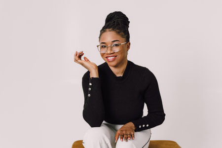 Young beautiful black woman feeling happy and excited in black shirt. Home conceptの写真素材