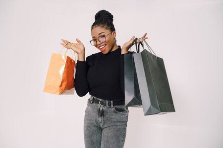 Portrait of young beautiful attractive African woman smiling and joyful with shopping bags.の写真素材