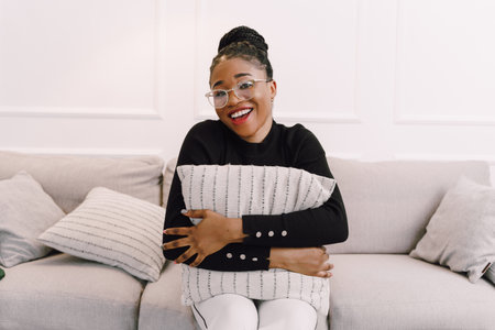 Young beautiful black woman feeling happy and excited in black shirt. Home conceptの写真素材