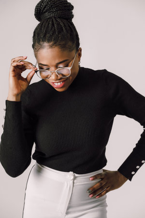 Young beautiful black woman feeling happy and excited in black shirt. Home conceptの写真素材