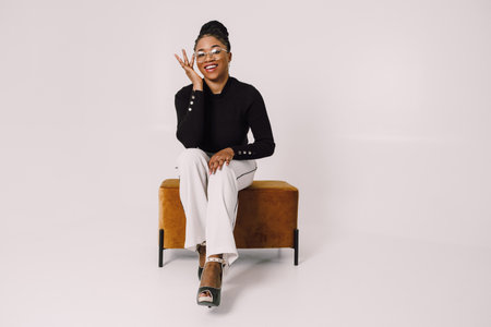 Young beautiful black woman feeling happy and excited in black shirt. Home conceptの写真素材