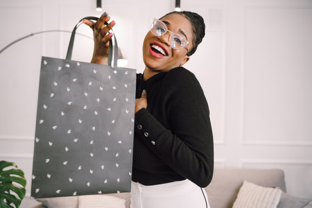 Portrait of young beautiful attractive African woman smiling and joyful with shopping bags.