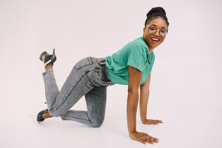 Attractive African American woman  in green shirt. Studio shot of wonderful black girl smiling on gray background.の写真素材