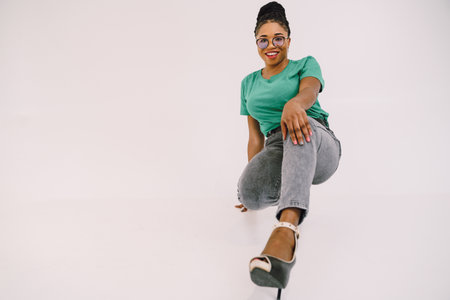 Attractive African American woman  in green shirt. Studio shot of wonderful black girl smiling on gray background.の写真素材