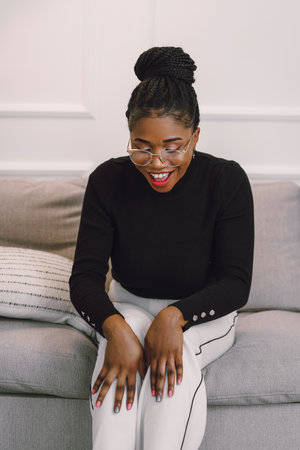 Young beautiful black woman feeling happy and excited in black shirt. Home conceptの写真素材