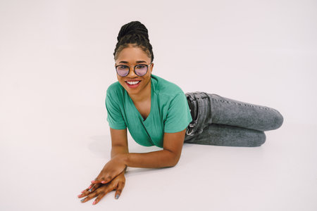 Attractive African American woman  in green shirt. Studio shot of wonderful black girl smiling on...