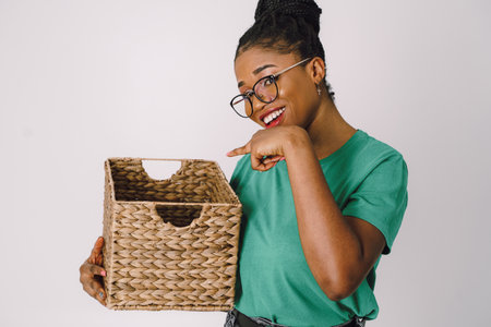 Beautiful African American woman standing holding basket. Happy Black girl in white background, Studio concept of wonderful black girl smiling on white background.の写真素材