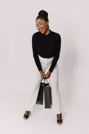 Portrait of young beautiful attractive African woman smiling and joyful with shopping bags.の写真素材