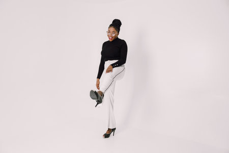 Young beautiful black woman feeling happy and excited in black shirt. Home conceptの写真素材