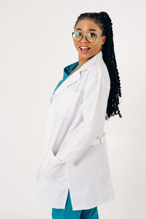 Portrait of a smiling african american female doctor wearing white coat and eyeglassesの写真素材