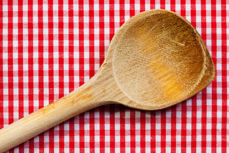 Antique wooden spoon for cooking with red white backgroundの写真素材