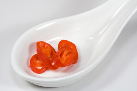hot peppers on a white spoonの写真素材