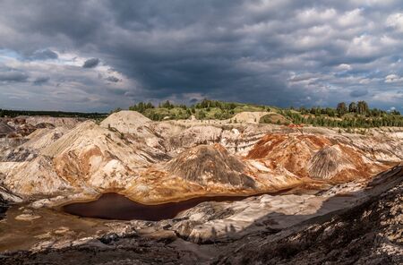 Panorama of abandoned clay quarry with bloody waterの写真素材