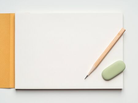 Blank page of sketchbook, pencil and eraser on white background. Flat layout