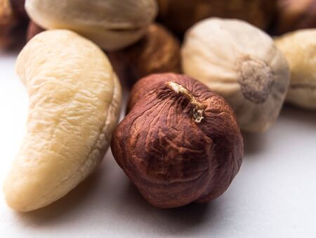 Blend of fresh healthy tasty nuts on white background