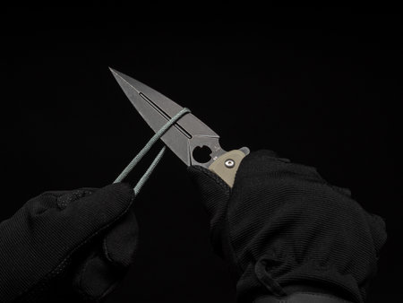 Hands in black gloves cut the cord with a pocket knife