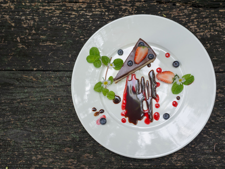 Choccolate Cheesecake with Strawberry and Blueberry on The Plate on The Wooden Background Top Viewの写真素材