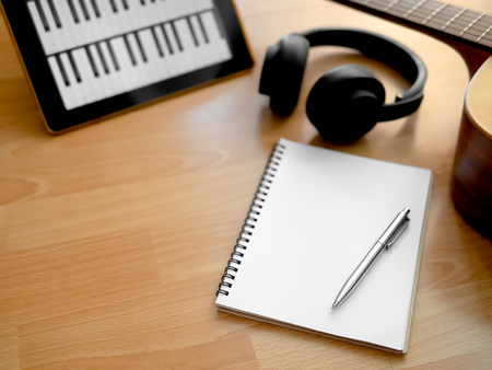 Music Creation Tools, Headphone, Guitar, Notebook, Electronic Tablet and Pen on Wooden Background