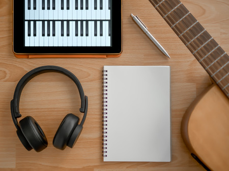 Music Creation Tools, Headphone, Guitar, Notebook, Electronic Tablet and Pen on Wooden Background Top Viewの写真素材