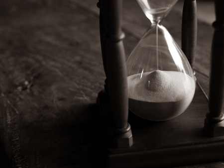 Close-up Vintage Wooden Hourglass on Wooden Background, Sand running through the bulbs for...