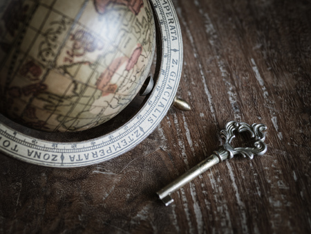 The Antique Key and The Old Wooden Classic World Globe on Old Wooden Backgroundの写真素材