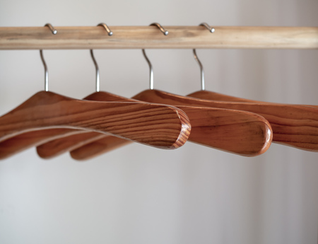 Close Up of Wooden Empty Hangers on White Wall Background in The Room. Soft focusの写真素材