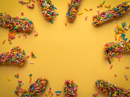 Bread Sticks with Chocolate and Colorful Topping with Space on Yellow Light Background for Fun Party...
