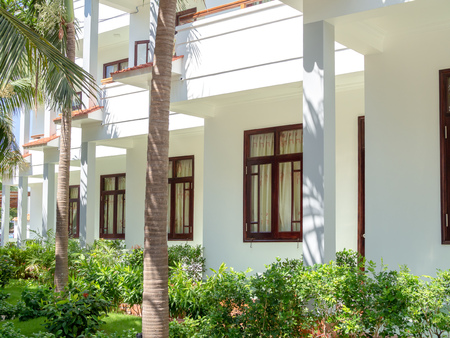 Modern White Beach House Bungalows with Coconut Palm Tree in The Gardenの写真素材