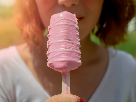 Beautiful Woman Short Hair Wearing White Shirt Eating Pink Popsicle Ice Pop Melting on Summer Time...