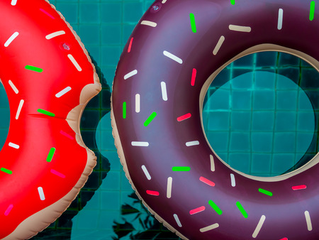 Colorful Pool Float Rings are Floating on Swimming Pool Background, Summer Conceptの写真素材