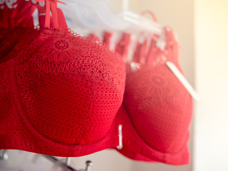 Row of Red Sexy Lace Bras Hanging on Shelf in Underwear Shopの写真素材