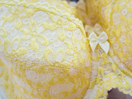 Close-up Row of Light Yellow Lace Bras Texture Backgroundの写真素材