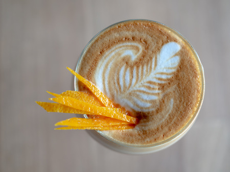 Flat Lay Close-up Cappuccino Romano Coffee Topping with Lemon or Orange Slice in Glass on Wooden Table Backgroundの写真素材