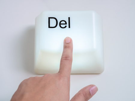 Finger is Pressing Big Delete Computer Key Button Light Box Isolated on White Background. Eraser Concept.の写真素材
