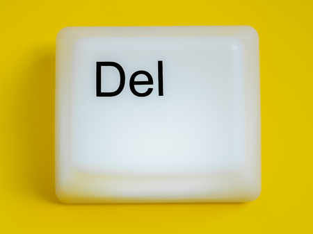 Flat Lay of Big Delete Computer Key Button Light Box Isolated on Yellow Background with Space. Eraser Concept.の写真素材