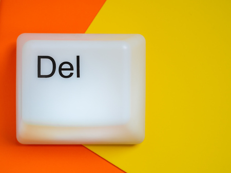 Flat Lay of Big Delete Computer Key Button Light Box Isolated on Yellow and Orange Background with Space. Eraser Concept.の写真素材