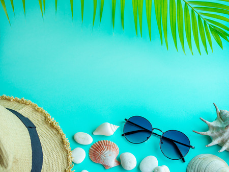 Flat Lay Beach Accessories, Beach Hat, Sunglasses with Beach Seashells and Beach Pebbles on Aqua Blue Background with Blank Space for Text. Top View Vacation Summer Concept.の写真素材