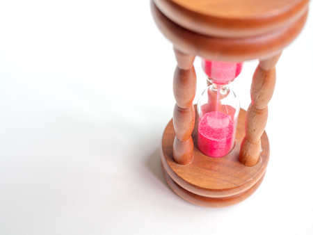 Close-up Wooden Vintage Hourglass with Pink Sand on White Background, Sand Running through the Bulbs...