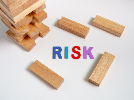 Risk Colorful Text with Tumble Tower Wooden Block Game on White Background. Business Conceptの写真素材