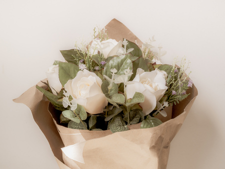 Artificial White Roses Bouquet in Wrapping Brown Craft Paper Isolate on White Background with Spaceの写真素材