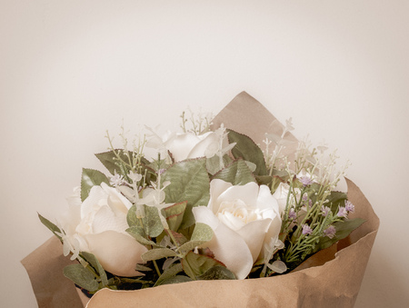 Artificial White Roses Bouquet in Wrapping Brown Craft Paper Isolate on White Background with Spaceの写真素材