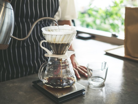 Barista Brewing Drip Coffee, Hand Pouring Hot Water from The Kettle over The Coffee Powder.の写真素材