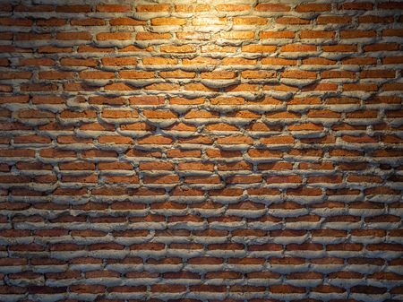 Brick wall background texture unique design. Cement overfall from joint of brick wall and the light from above.の写真素材