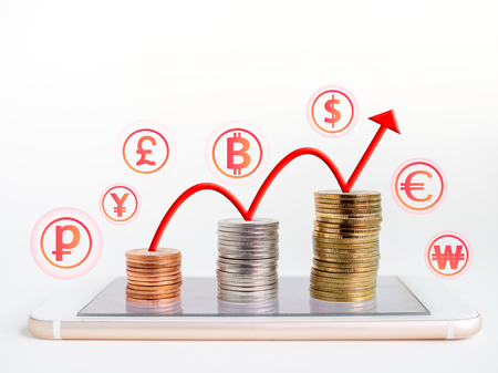 Making money online. Business financial online concept. money, stack of colourful coins on mobile phone with red rising up arrow graph on coins and currency icons on white background with copy space.の写真素材