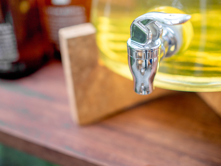 Yellow organic body care in refill cooler bottle on wooden table background.の写真素材
